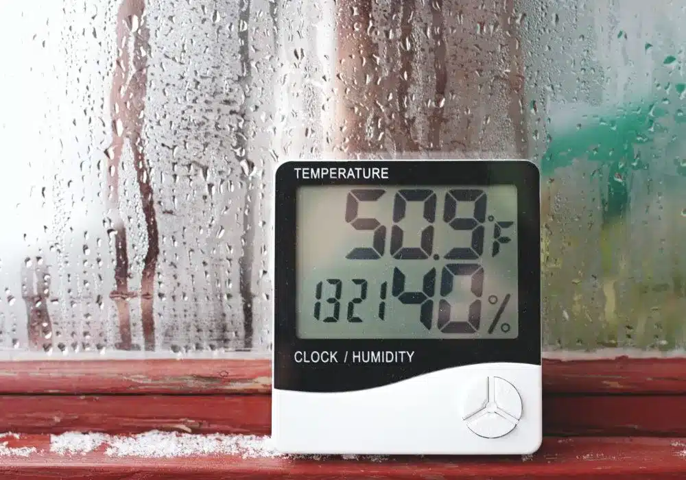 Common Signs of Humidity Issues in Your House 1 A digital thermometer and hygrometer displays 50.9°F and 40% humidity, positioned against a condensation-covered window.