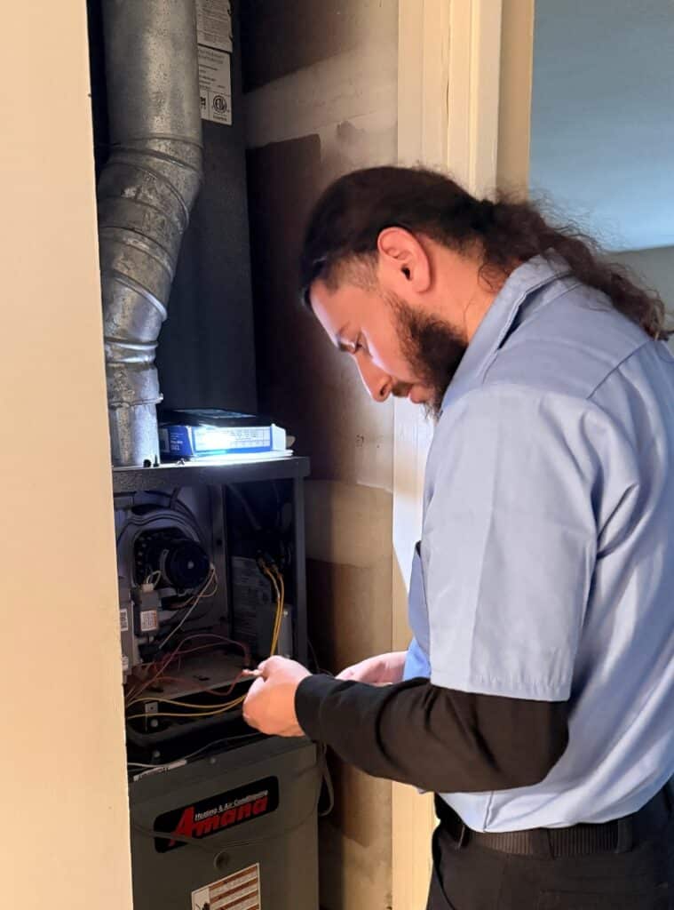 Prime Genius HVAC technician repairing the internal wiring and components of a residential furnace in the Sacramento area.